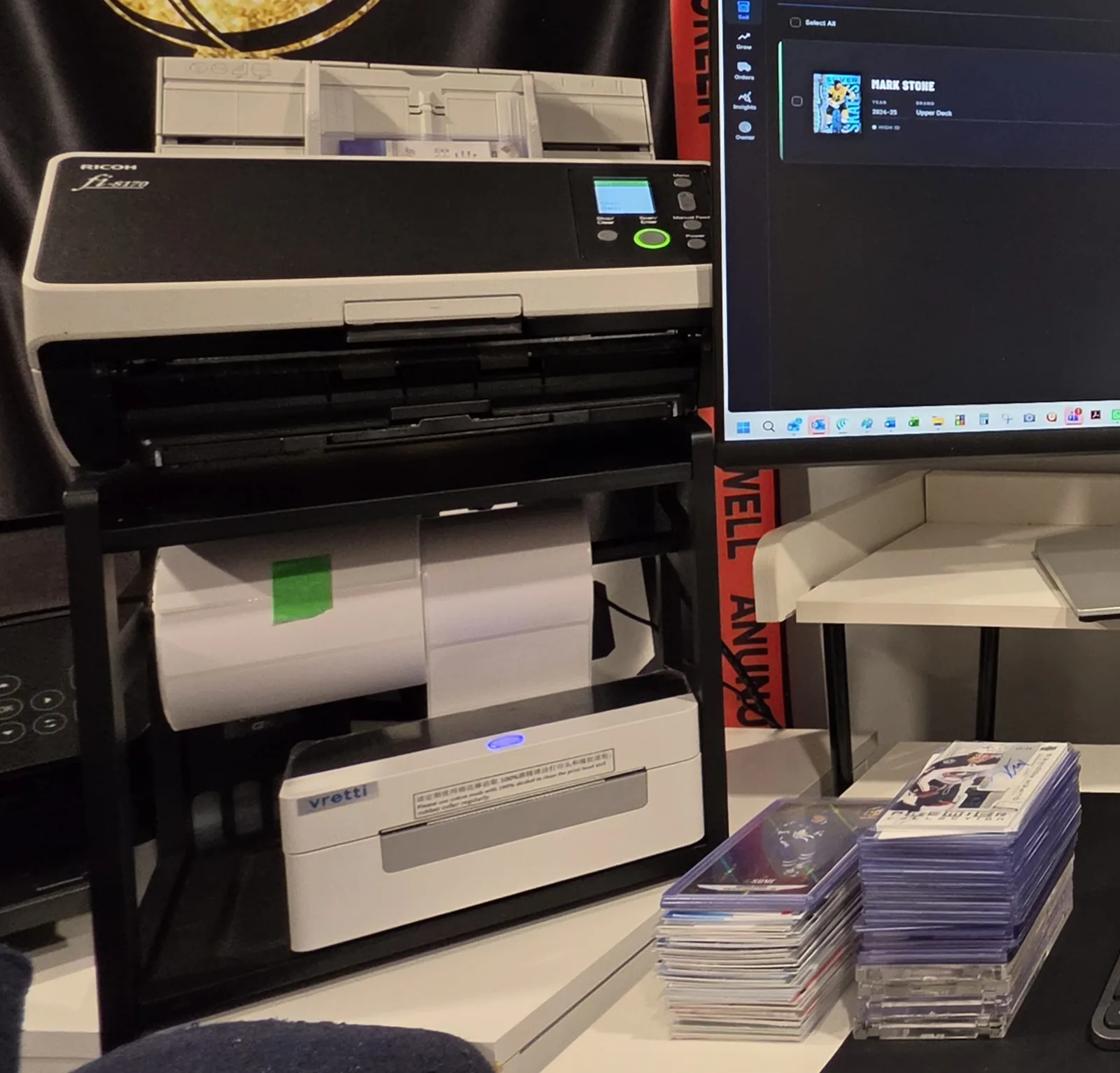 Ricoh fi-8170 scanner on the Loubs Cards desk with sleeved hockey cards loaded in the feeder and stacks of sleeved and top-loaded cards beside it